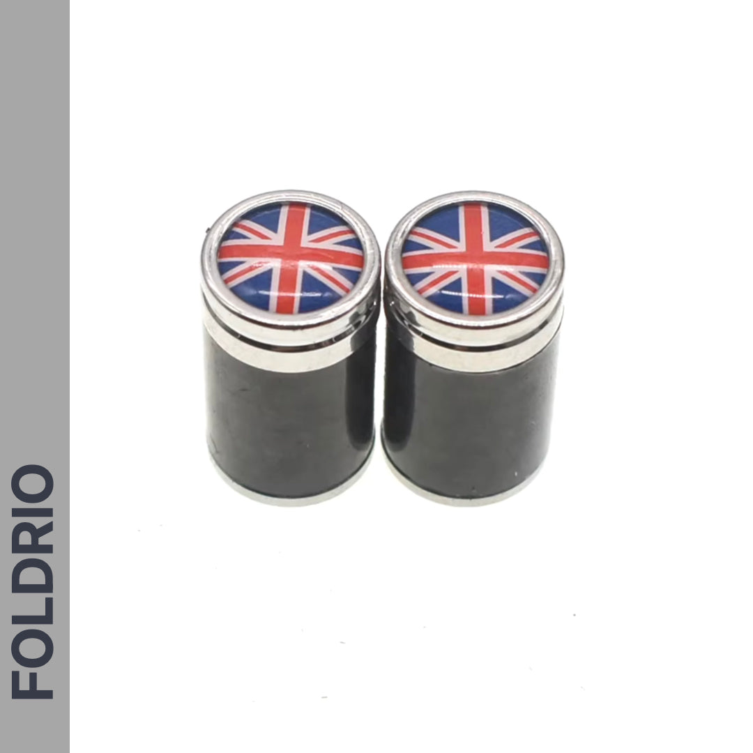 Two FOLDRIO Brompton Union Jack Valve Caps – Schrader (A/C/G Line), small and cylindrical with lids, are side by side on a white background. The word FOLDRIO is displayed vertically on the left edge.