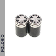 Two black cylindrical containers with metallic lids featuring a monochrome Union Jack are shown side by side. Ideal for storing Brompton Union Jack Valve Caps – Schrader (A/C/G Line) by FOLDRIO, whose name appears vertically on the left.