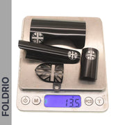 A set of four black FOLDRIO Brompton Frame Protectors with white British flag designs is shown on a digital scale reading 135g, placed on a white surface with "FOLDRIO" written vertically on the left.