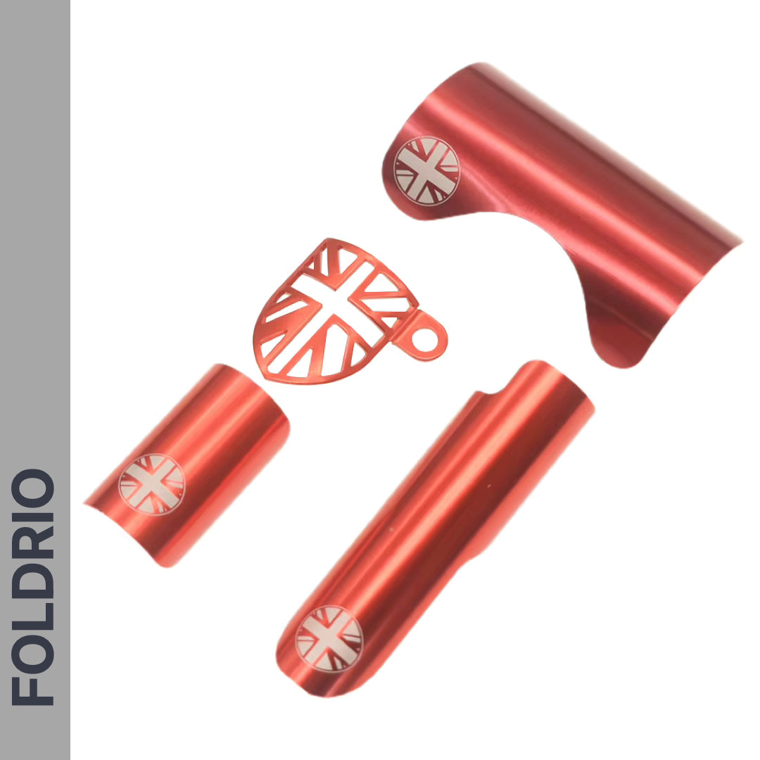 The FOLDRIO Brompton Frame Protector Set with British Flag features four metallic red parts, each with a silver and red Union Jack emblem, arranged on a white background with "FOLDRIO" displayed vertically on a grey side bar.