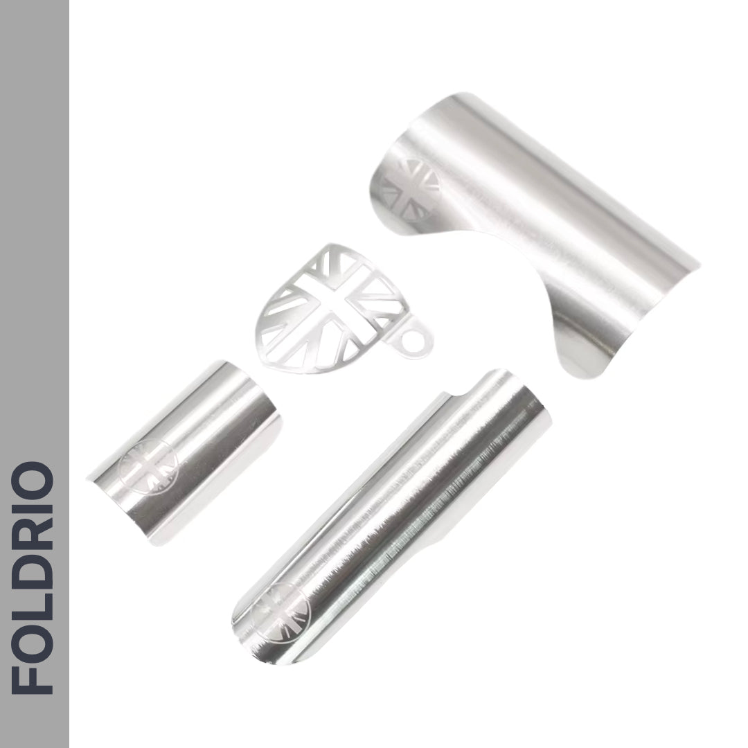 Four silver metal Brompton Frame Protector Sets with a British flag design by FOLDRIO are shown on a white background, with the FOLDRIO brand name vertically on a grey bar at the left.