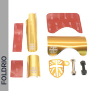 The FOLDRIO Brompton Frame Protector Set with British Flag, including gold-colored protectors, adhesive strips, a Union Jack keychain, and two screws, is arranged on a white background. "FOLDRIO" appears vertically on the left side.
