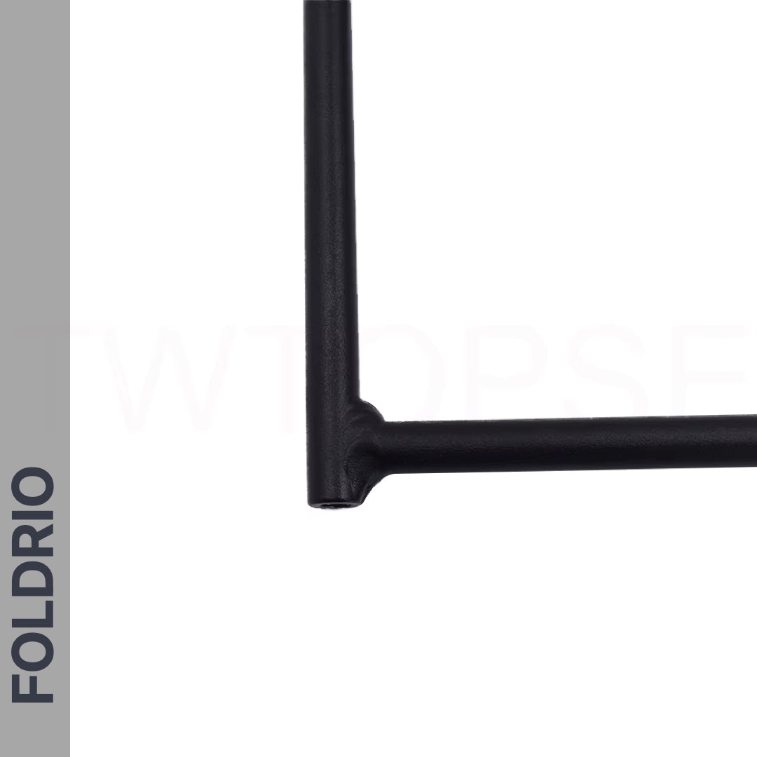 Close-up of a black metal frame corner on white with a vertical gray bar displaying "FOLDRIO"—the Brompton Rear Rack, a lightweight aluminium cargo rack, designed for easywheel mount compatibility.