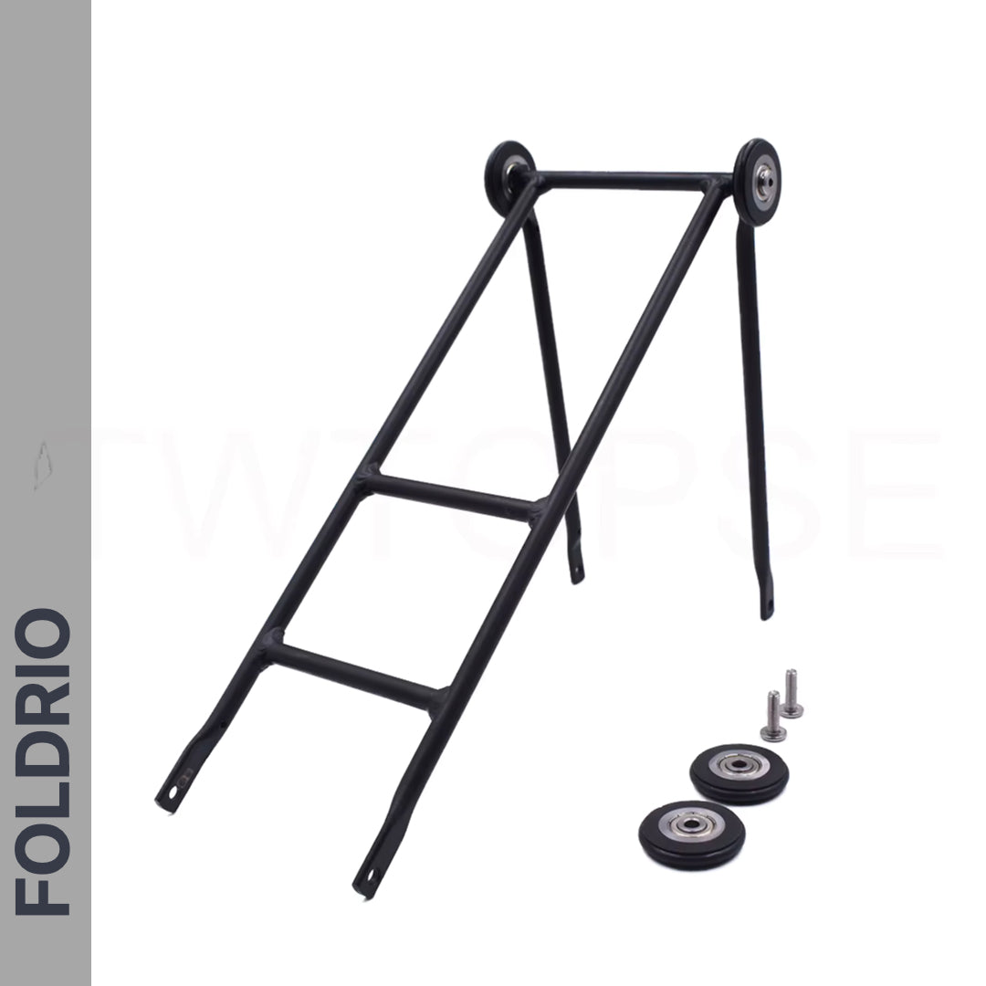 The Brompton Rear Rack – Lightweight Aluminium Cargo Rack in black is shown with easywheel mounts, two small wheels, two loose wheels, and screws on a white background. "FOLDRIO" appears vertically on the grey side panel.