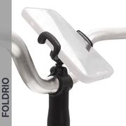 A smartphone is mounted on a bicycle handlebar with the FOLDRIO Brompton Phone Mount – Lightweight, No Case Needed. The word FOLDRIO appears vertically on the left side of the image.