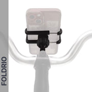 A Brompton Phone Mount – Lightweight, No Case Needed by FOLDRIO is mounted at the center of bicycle handlebars with a smartphone attached. "FOLDRIO" appears vertically on the left. The image has a white background and faint shadow effect.