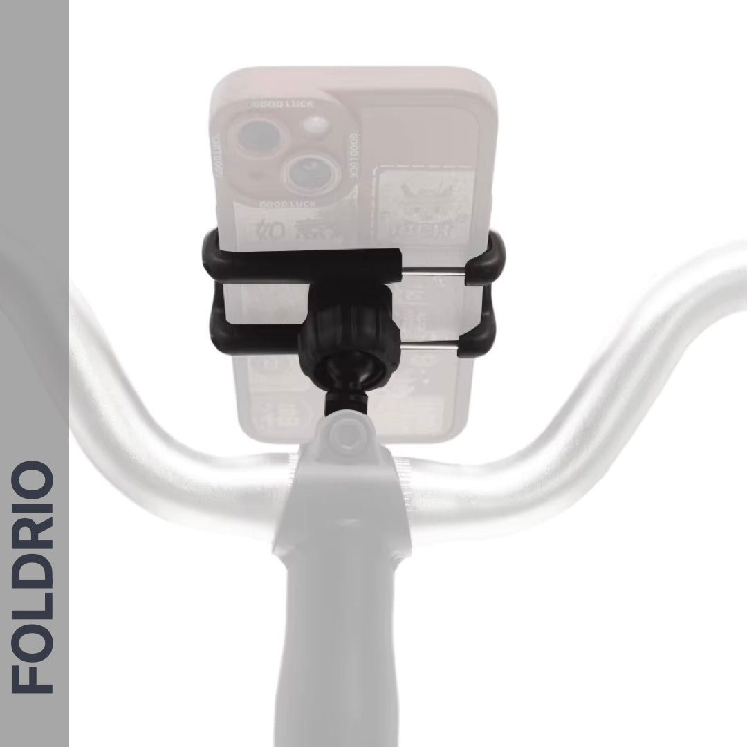A Brompton Phone Mount – Lightweight, No Case Needed by FOLDRIO is mounted at the center of bicycle handlebars with a smartphone attached. "FOLDRIO" appears vertically on the left. The image has a white background and faint shadow effect.