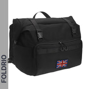The FOLDRIO Brompton Roll-Top Front Bag (27.5L) is a black commuter backpack with a front zip pocket, two buckle straps, and a UK flag patch. "FOLDRIO" appears vertically on the left side of the image.