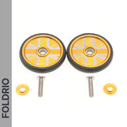 Two gold and black FOLDRIO Brompton Easy Wheels Union Jack Edition with titanium bolts and washers are displayed on a white background, with "FOLDRIO" vertically on the left.