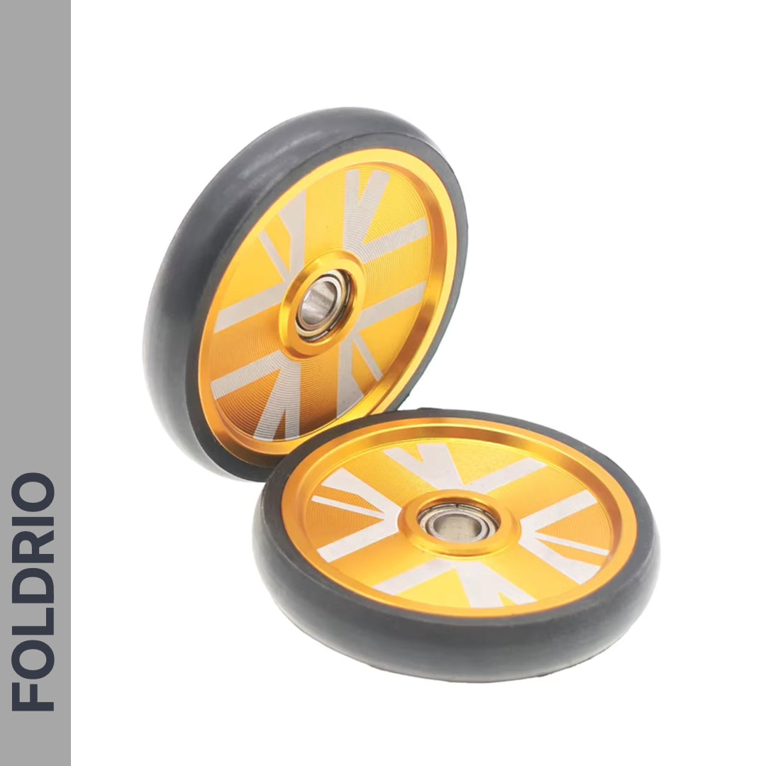 Two orange and silver lightweight alloy bike wheels with black edges, shown on a white background. FOLDRIO appears on a grey sidebar. Brompton Easy Wheels Union Jack Edition with Titanium Bolts—ideal for Brompton upgrades.