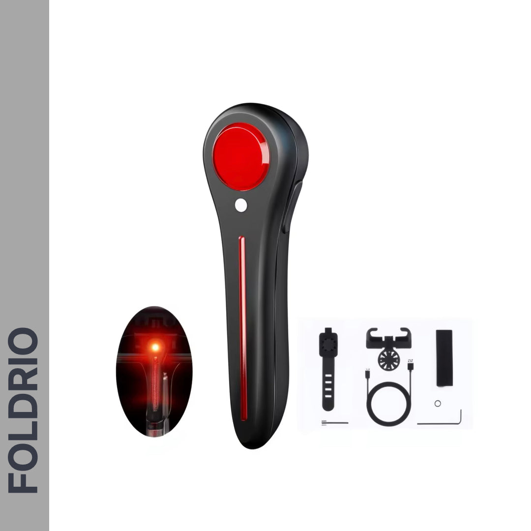 The FOLDRIO Brompton Smart Brake Tail Light is a black and red handheld device with a strap, charging cable, and mounting accessories. "FOLDRIO" appears vertically on the side. Perfect as a bike saddle mount holder or brake sensor rear light.