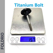 A Brompton Rear Shock Absorber by FOLDRIO rests on a digital scale, showing its weight. "Brompton Rear Shock Absorber" is at the top, and "FOLDRIO" appears vertically along the left side.