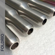 Four metallic, cylindrical Brompton Titanium Seatpost – Multicolour Edition tubes by FOLDRIO are arranged parallel on a textured white background. The FOLDRIO brand name is vertically printed along the left side of the image.