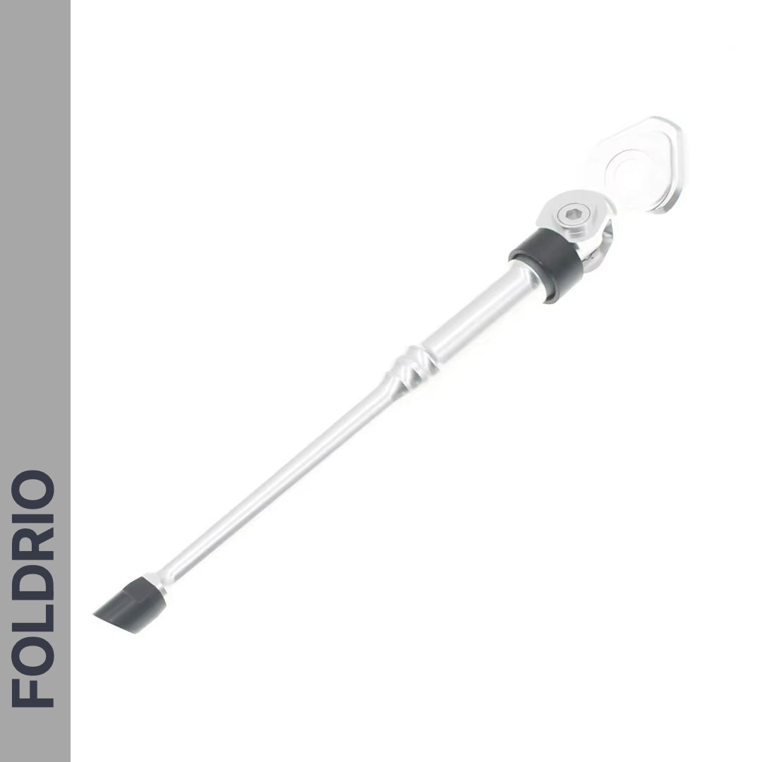 The FOLDRIO Brompton Kickstand – Adjustable Aluminium for A and C Line is shown on a white background, featuring a silver design with black rubber foot, rear axle mount, and "FOLDRIO" vertically on a gray stripe—perfect for Brompton bikes.