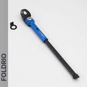 A lightweight blue and black Brompton Kickstand – Carbon Fibre, P and T Line by FOLDRIO, with a separate black mounting ring, rests on a white surface. The word FOLDRIO appears vertically along the left edge.