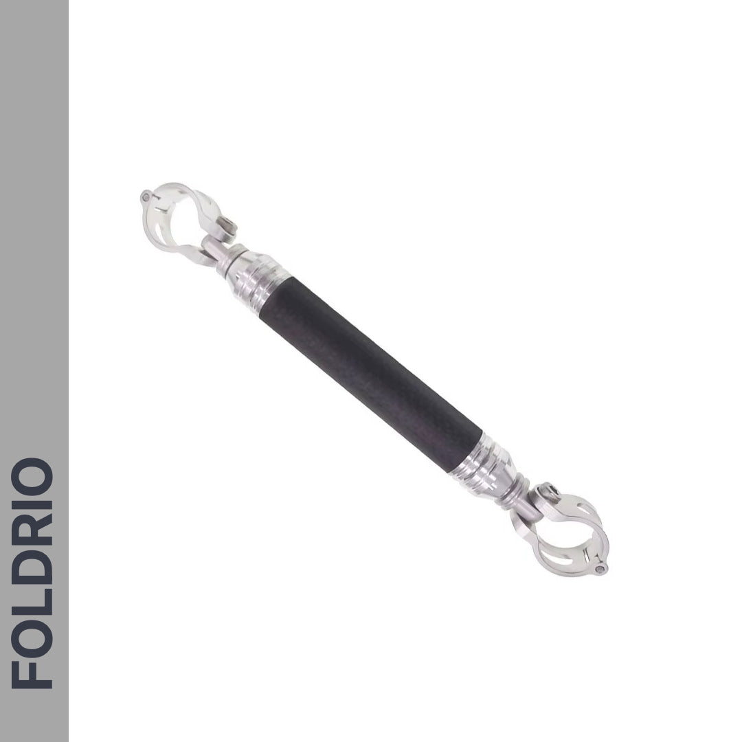 A Brompton M Handlebar Cross Brace by FOLDRIO, shown diagonally on a white background, features clamp-style connectors at both ends. The adjustable cylindrical bar is part of a 6-colour range, with "FOLDRIO" vertically on a gray left sidebar.