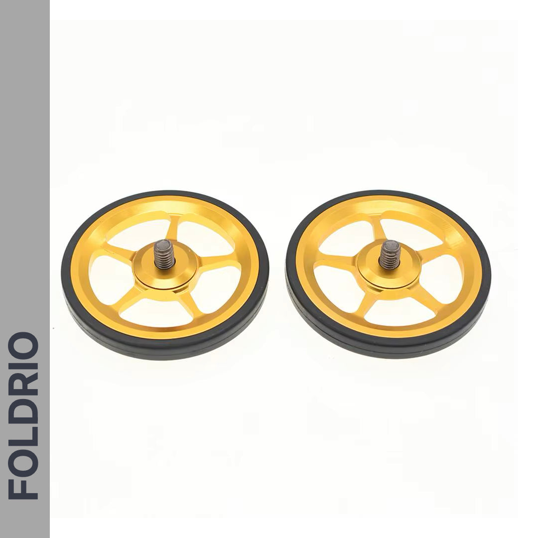 Brompton Brompton gold alloy easy wheels with black edges and center bolts, displayed side by side; FOLDRIO branding visible | Foldrio. Foldrio