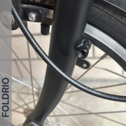 Brompton Brompton front fork close-up showing brake cable, wheel spokes, and Foldrio protective frame sticker for lasting bike protection | Foldrio. Foldrio