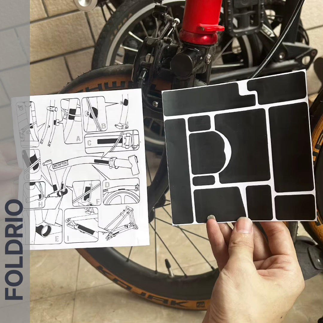 Brompton Brompton black FOLDRIO protective sticker set and instructions held before a red-framed bike; FOLDRIO branding shown | Foldrio. Foldrio